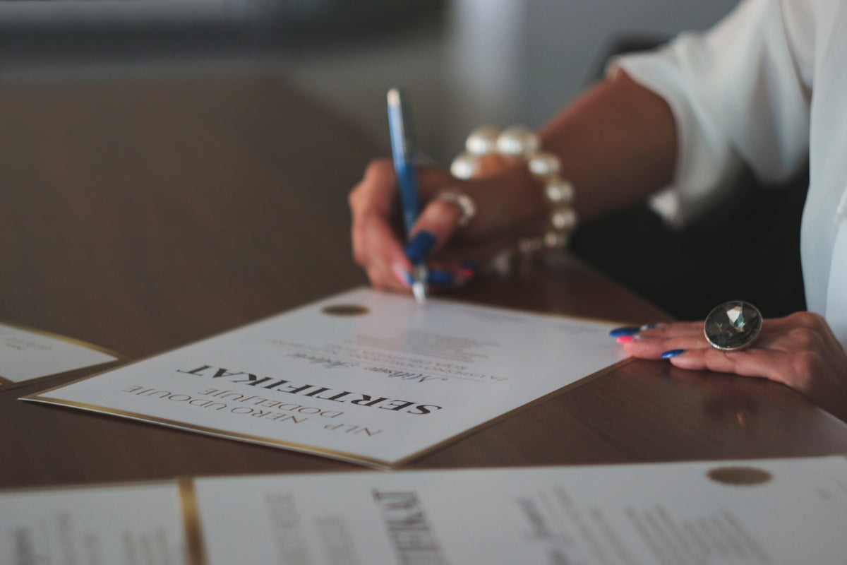 a woman writing on a piece of paper Image