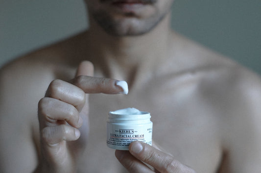 a man holding a jar of cream in his hand
