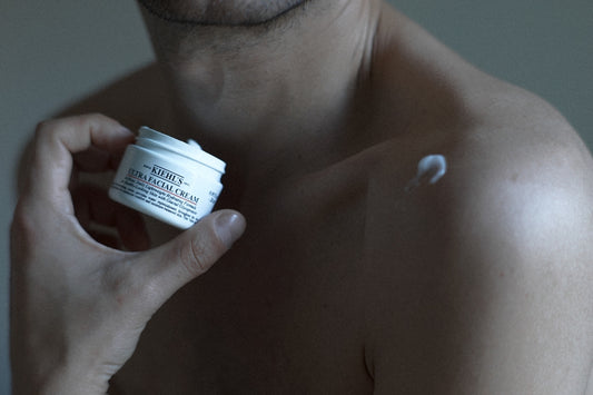 a man holding a jar of cream in his hand