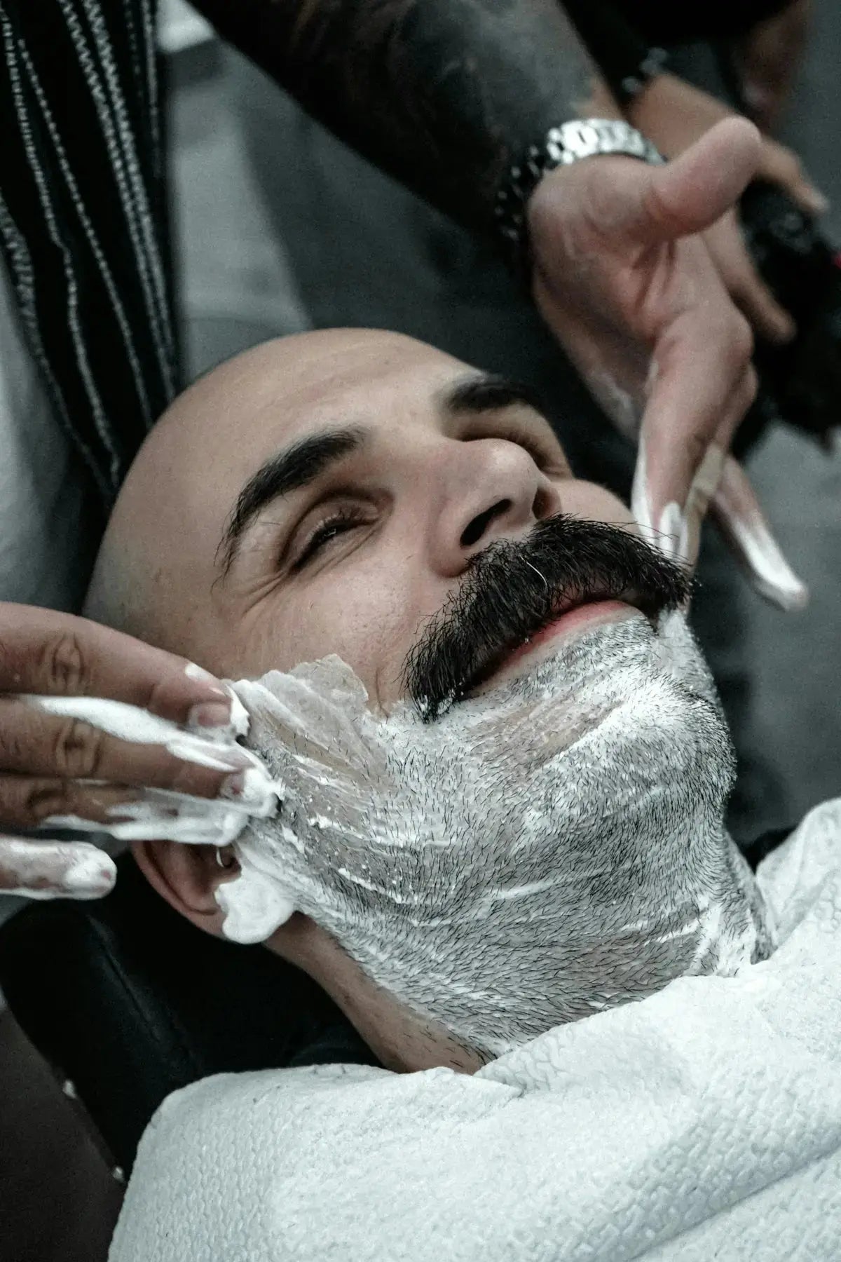 A man getting his hair cut by a barber Image