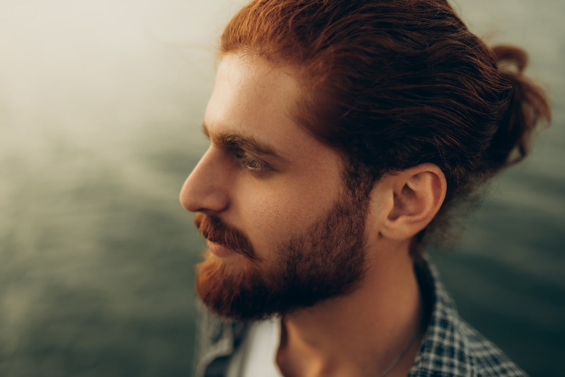 Man with red hair and beard looks to the side