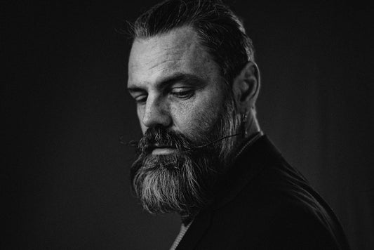 A thoughtful man with a beard and mustache.